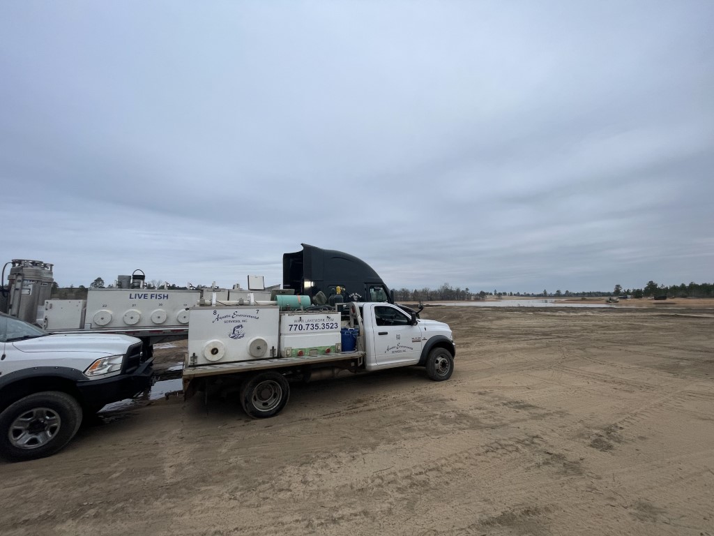 Truck with live fish near lake bed
