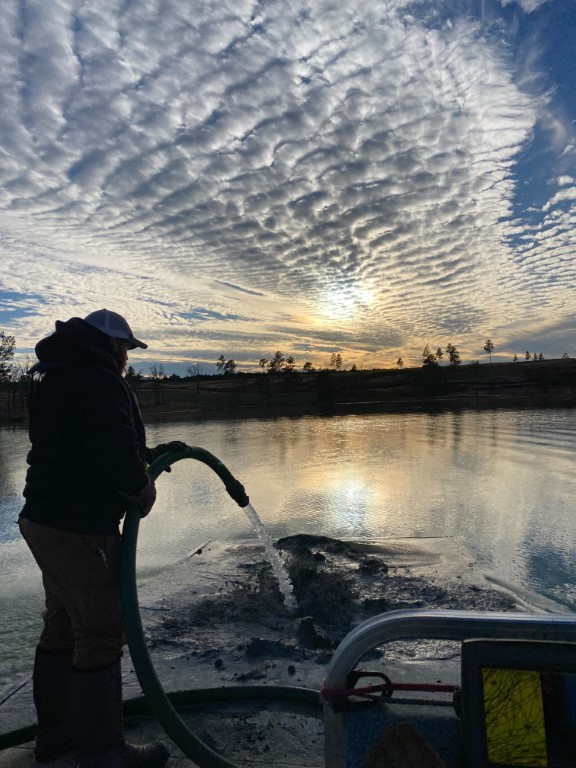 Silhouetted shot of AES worker liming lake