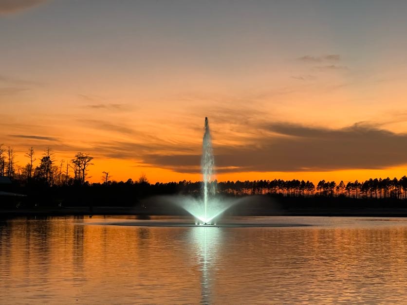 fountain with sunset behind it